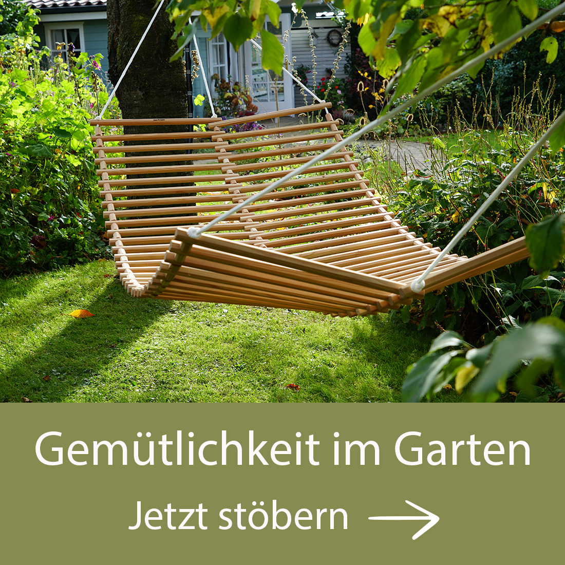 Hängematte aus Holzlatten in einem grünen Garten, umgeben von Pflanzen. Darunter Text: Gemütlichkeit im Garten. Jetzt stöbern. Bild verlinkt auf die Landingpage Gemütlichkeit im Garten.