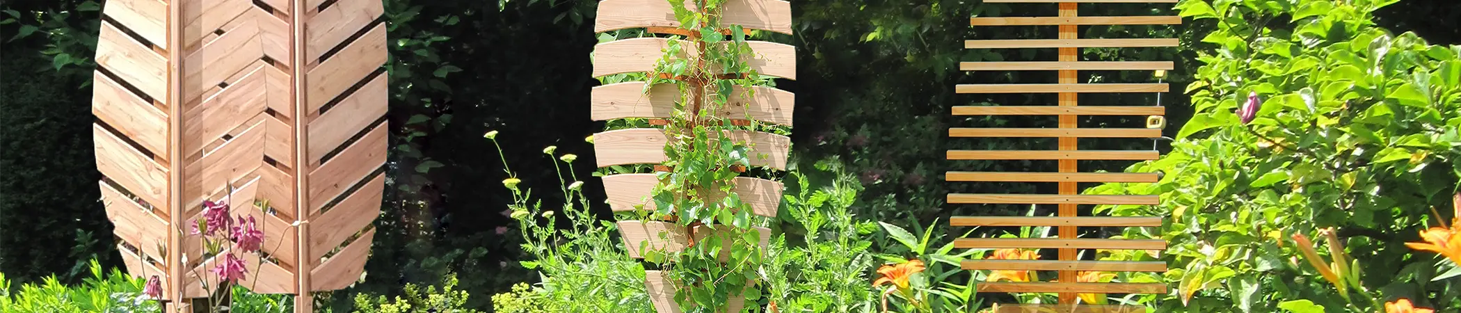 Holz-Sichtschutzwände in Blattformen stehen in einem üppigen Garten mit Kletterpflanzen und bunten Blüten im Vordergrund. Im Hintergrund ist dichtes grünes Blattwerk sichtbar.